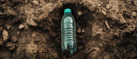 A plastic water bottle is half-buried in dirt, highlighting environmental pollution and waste issues. photo