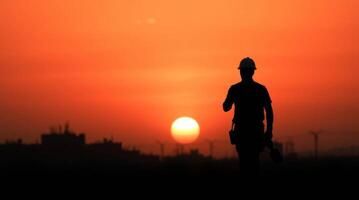 Silhouette of construction worker at sunset reflecting industrial progress photo
