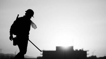 Silhouette of construction worker walking at sunset on building site photo
