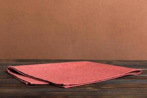 top view with red empty kitchen napkin isolated on table background. Folded cloth for mockup with copy space, style photo