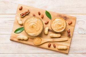 Bowl peanut butter and peanuts table background. top view with copy space. Creamy peanut pasta small bowl photo