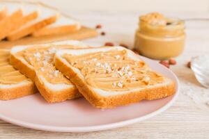 Peanut butter sandwiches toasts light table background.Breakfast. Vegetarian food. American cuisine photo