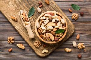 mixed nuts bowl. Mix various nuts colored background. pistachios, cashews, walnuts, hazelnuts, peanuts photo