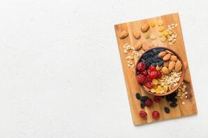Cooking wholesome breakfast. Granola with Various dried fruits and nuts in a bowl. The concept of a healthy dessert. Flat lay, top view photo