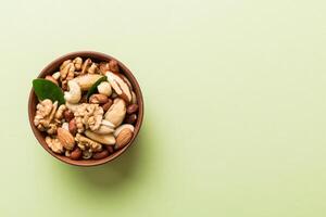 mixed nuts in bowl. Mix various nuts on colored background. pistachios, cashews, hazelnuts, peanuts , brazil nuts photo