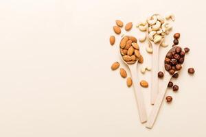 Assortment nuts in wooden spoon colored table. Cashew, hazelnuts, walnuts, almonds. Mix of nuts Top view with copy space photo