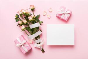 Greeting holiday card mockup with fresh roses on colored table background, copy space for design photo