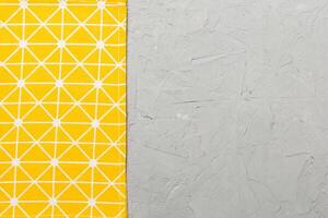 top view with yellow empty kitchen napkin isolated on table background. Folded cloth for mockup with copy space. Minimal style photo