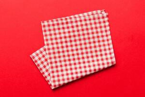 top view with red empty kitchen napkin isolated on table background. Folded cloth for mockup with copy space, Minimal style photo