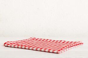 top view with red empty kitchen napkin isolated on table background. Folded cloth for mockup with copy space, photo