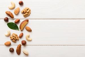 Composition of nuts , flat lay mix hazelnuts, cashews, almonds on table background. healthy eating concepts and food background photo