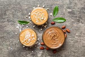 Glass jar with peanut butter table background, top view space for text and close up photo