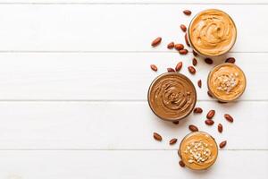 Glass with peanut butter on table background, top view space for text and close up photo