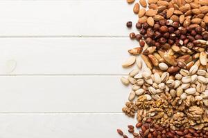 different nuts frame background. Close up, top view, flat lay with vopy space. Walnut, pistachios, hazelnuts and cashews photo