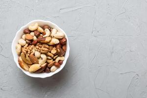 mixed nuts bowl. Mix of various nuts on colored background. pistachios, cashews, walnuts, hazelnuts, peanuts and brazil nuts photo