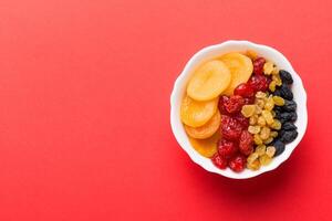 Bowl different dried fruits on table background, top view. Healthy lifestyle with copy space photo