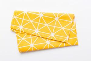 top view with yellow empty kitchen napkin isolated on table background. Folded cloth for mockup with copy space, Minimal style photo