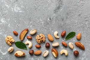 Composition nuts , flat lay mix hazelnuts, cashews, almonds on table background. healthy eating concepts and food background photo