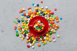 Coffee cup chocolates and colored candy. Top view table background with copy space photo