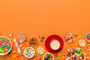 Coffee cup with chocolates and colored candy. table background with copy space photo