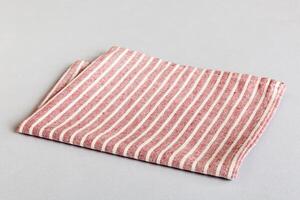 top view with red empty kitchen napkin isolated on table background. Folded cloth for mockup copy space, Minimal style photo