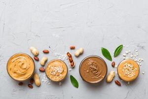 Glass jar with peanut butter table background, top view space for text close up photo
