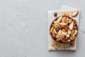 mixed nuts in bowl. Mix various nuts on colored background. pistachios, cashews, walnuts, hazelnuts, peanuts and brazil nuts photo
