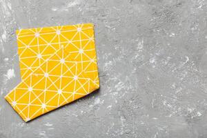top view yellow empty kitchen napkin isolated on table background. Folded cloth for mockup with copy space, Minimal style photo