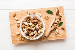 mixed nuts bowl. Mix various nuts colored background. pistachios, cashews, walnuts, hazelnuts, peanuts and brazil nuts photo