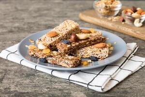 Various granola bars table background. Cereal granola bars. Superfood breakfast bars with oats, nuts and berries, close up. Superfood concept photo