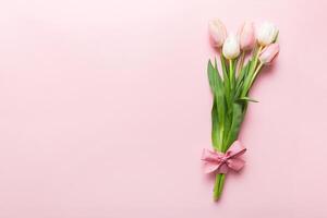 Bouquet of pink tulips colored table background . Top view with copy space. Waiting for spring. Happy Easter card. Flat lay photo