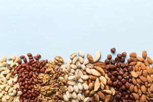 different nuts frame background. top view, flat lay with vopy space. Walnut, pistachios, almonds, hazelnuts and cashews photo