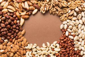 different nuts frame background. flat lay with vopy space. Walnut, pistachios, almonds, hazelnuts and cashews photo