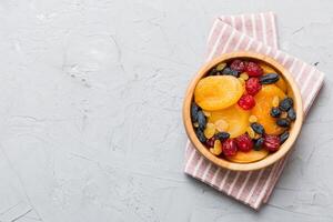 Bowl with different dried fruits table background. Healthy lifestyle with copy space photo