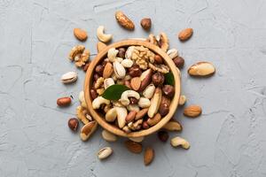 mixed nuts in bowl. Mix various nuts colored background. pistachios, cashews, walnuts, hazelnuts, peanuts and brazil nuts photo