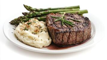 Gourmet Dinner Plate with Grilled Steak, Mashed Potatoes, and Asparagus Garnished with Fresh Herbs photo