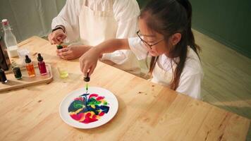 Mother and child explore science together with milk and colors video