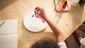 Top View of Child Dropping Food Coloring into Milk for Science Experiment video