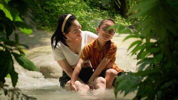 Relaxed moment in nature with mother and child enjoying water together video