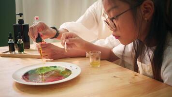 Mother and Child Doing Surface Tension Experiment with Focused Attention video