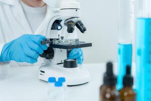 Scientist analyze biochemical samples in advanced scientific laboratory. Medical professional use microscope look microbiological developmental of viral, Biotechnology research in science lab. photo