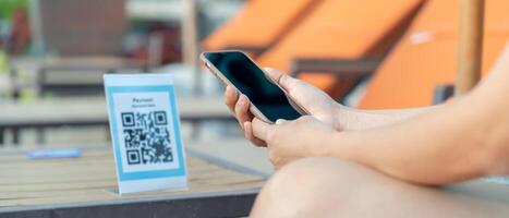 Woman use smartphone to scan QR code to pay in cafe restaurant with a digital payment without cash. Choose menu and order accumulate discount. E wallet, technology, pay online, credit card bank app. photo