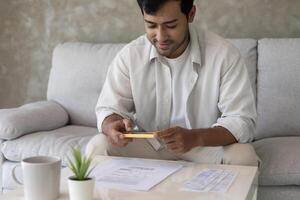 man use phone scan barcode or QR codes to pay credit card bill after receiving document invoice online. payment, receive, paying electricity, digital payments without money, technology photo