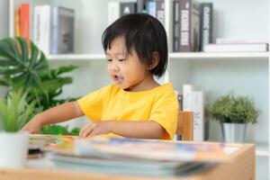 Asian children relax read book at home. daughter and reading a story. learn development, childcare, laughing, education, storytelling, practice, imagine reduce addiction mobile phone photo