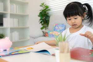 Happy Asian children relax read book at home. daughter and reading a story. learn development, childcare, laughing, education, storytelling, practice, imagine reduce addiction photo