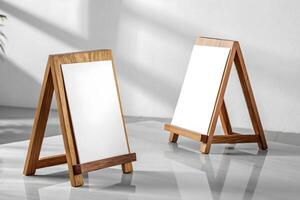 Two wooden easel stands with blank white canvas on a shiny gray surface under soft natural light photo