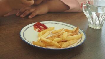Child enjoys dipping fries in ketchup at a casual dining table video