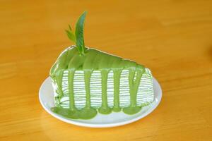 Matcha Crepe Cake is a sweet dessert menu with soft crepe dough, thin layers with a light green tea aroma, arranged alternately with sweet and smooth red bean cream, soft and fluffy. photo