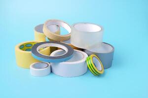 many different kind of scotch tapes on a blue background photo