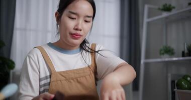 Handheld selective focus shot, Woman's hand using knife to peel dragon fruit on wooden cutting board at table. video